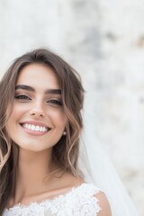 Fototapeta premium Smiling young woman in a lace bridal dress outdoors with soft background