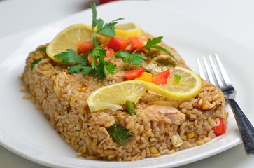 A food shot of  the iconic Lebanese dish fish and rice. A dish made from fish fillet and rice served along a tahini salad.