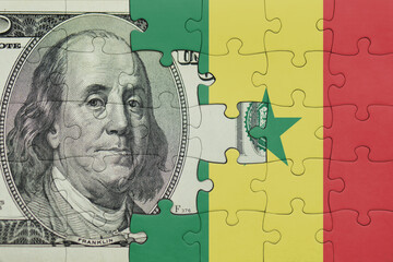 puzzle with the national flag of senegal and the usa dollar money .finance concept