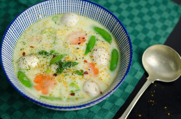 Thai Tom Kha Gai coconut milk soup with vegetables on a black table, Asian recipe ideas, home cooking ideas