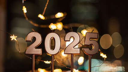Happy new year 2025 with festive lights at night. Golden candles 2025 with bokeh stars lights