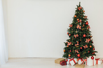 Christmas tree with gifts decorated with red toys lights garland in the interior for the new year