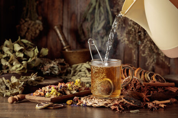 Glass of herbal tea with various dried herbs, flowers, and spices.