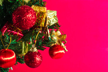 Christmas tree decorations on a vibrant red background with copy space
