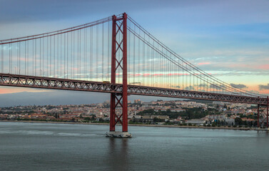 Obraz premium Panoramic Exposure done from a Cruise ship, while arriving at Lisbon at sunrise, of the 25th April Bridge and Tagus River, with Lisbon on the left bank and the Sanctuary of Christ the King, Lisbon,Por