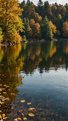 Obraz premium Lake scene with yellow, green, and brown autumn leaves.