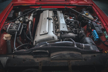 Inline six engine of a classic, luxury car exposed as bonnet is removed.