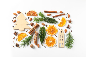 Different spices, dried orange slices and fir tree branches on white table, flat lay. Christmas season