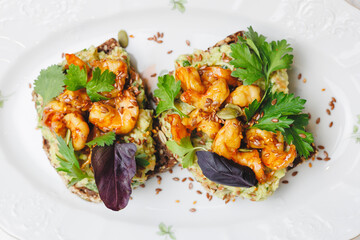 Toast with shrimp, guacamole and herbs.