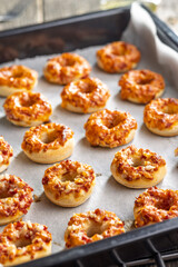 Mini pizza bagels on baking paper.