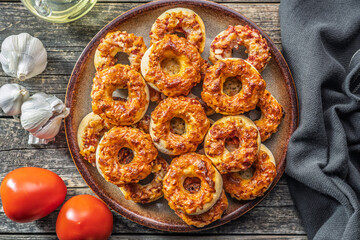 Mini pizza bagels on plate on wooden table. Top view.