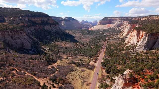 A stunning aerial view of Zion National Park is captured, showcasing the impressive red rock formations and the breathtaking scenic landscapes during a picturesque sunset that envelops the area