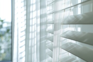 A close-up shot of a window with white blinds partially open, allowing natural light to filter in