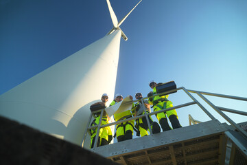 A group of  workers in high-visibility gear joyfully high-fives each other after completing their...