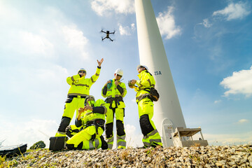 A group of  workers in high-visibility gear joyfully high-fives each other after completing their...