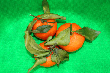 Fresh tangerines with leaves on a colored background, fruits, vitamins.