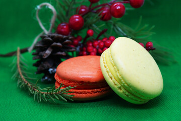 A spruce branch with a pine cone and multi-colored macaroons on a beautiful background, holiday, Christmas.