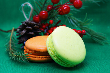 A spruce branch with a pine cone and multi-colored macaroons on a beautiful background, holiday, Christmas.