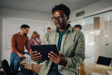 Focused businessman using digital tablet during office meeting