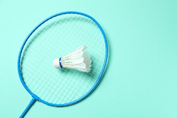 Badminton racket and white badminton shuttlecock on color background