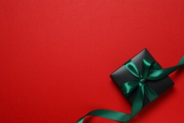 Beautiful gift box tied with bow on color background 