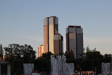 Stunning Modern Skyscrapers Silhouetted at Sunset with a Serene Fountain in the Foreground