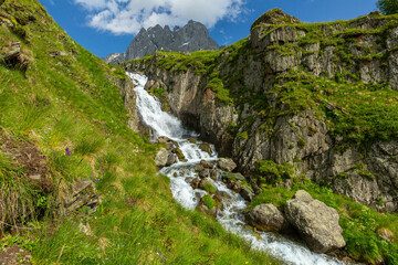 Hiking trail to Chaukhi mount from the village of Juta. Beautiful waterfall under Chaukhi. Chaukhistskhali river. Breathtaking landscape.