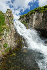 Hiking trail to Chaukhi mount from the village of Juta. Beautiful waterfall under Chaukhi. Chaukhistskhali river. Breathtaking landscape.