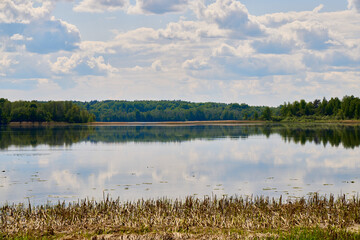 The beautiful scenery of a serene lake reflecting under a vivid azure sky captivates all