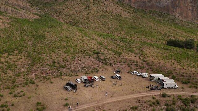 horizontal drone video of Durango dessert with mountains in sunset with small lake and trucks at John Wayne ranch 