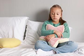 Fototapeta premium Autism concept. Lonely little girl with pillow on bed at home