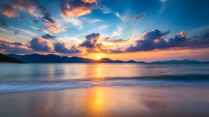 Fototapeta premium Stunning sunset over tranquil ocean waves and mountain silhouette