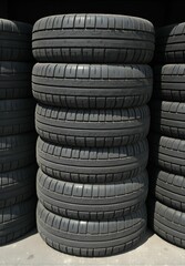 Obraz premium A tall stack of old, weathered car tires piled together, showing wear and tear from years of use.