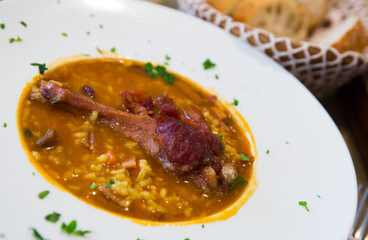 Tasty duck leg stewed with rice and mushrooms served on plate