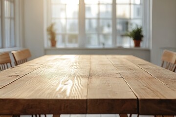 Wooden table in a bright room with potted plants and sunlight streaming through windows