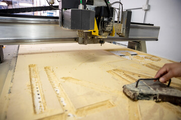 Operator working on a plasma cutting machine for different substrates such as MDF board.