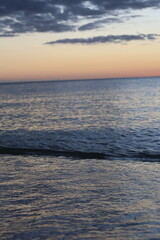 Obraz premium sunset over the ocean evening on sea with small waves yellow sky with dark clouds