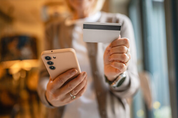close up of mature woman hands shop online with credit card