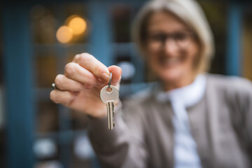 close up of woman hand hold key of apartment