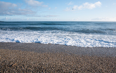 Picturesque beach with small waves sea foam new zealand west coast