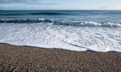 Picturesque beach with small waves sea foam new zealand west coast
