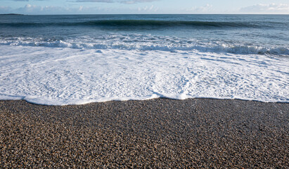 Picturesque beach with small waves sea foam new zealand west coast