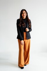 Stylish woman in black blazer and orange pants.