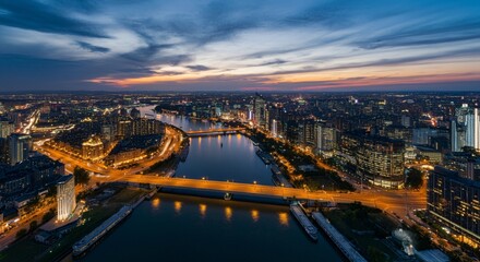 Fototapeta premium Aerial view of a cityscape with lights glowing at twilight