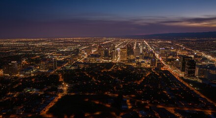 Obraz premium Aerial view of a cityscape with lights glowing at twilight