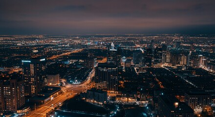Fototapeta premium Aerial view of a cityscape with lights glowing at twilight