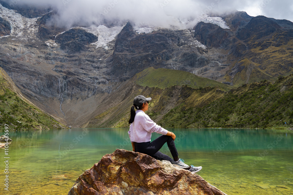 Wall mural Young tourist enjoying the Humantay Lagoon at an altitude of 4200 meters above sea level in Cusco, Peru.