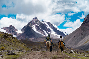 Travelers riding on the route of the Ausangate snow-capped mountain in Cusco, Peru.