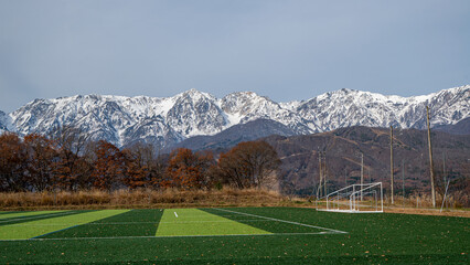紅葉の山並みと冠雪した北アルプス
