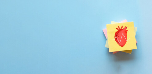Yellow sticky note with heart and heart beat icon on blue background., healthcare, wellness, and heart health, ideal for themes of medical diagnostics, health monitoring, and innovative healthcare.